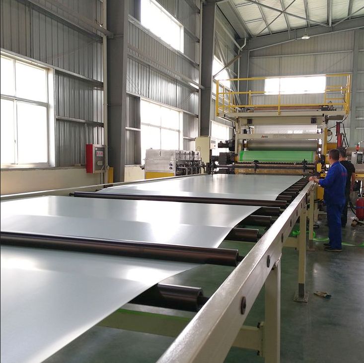 Interior of a modern factory showing production machines, equipment, and organized workstations in a spacious industrial hall.